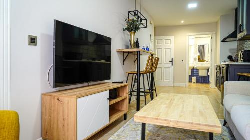 a living room with a flat screen tv on a wall at Apartamentos Puente Romano Suites Parking Gratis in Merida