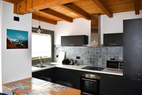 eine Küche mit schwarzen Schränken und einer Arbeitsplatte in der Unterkunft Our Happy Place - casa vacanze per il viaggiatore Slow in Mandello del Lario