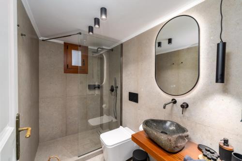 ein Bad mit einem Waschbecken und einem Spiegel in der Unterkunft Villa Antonis in Chalki