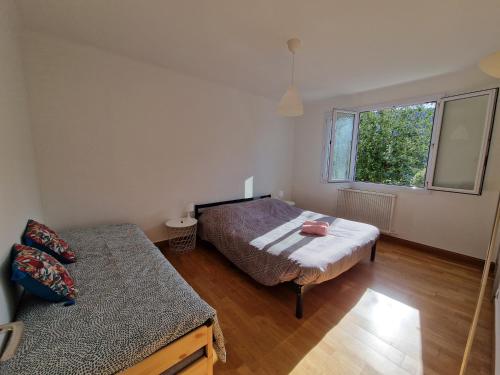 a bedroom with a bed and a window at Maison 6 chambres Saint Nazaire 5 min de la mer in Saint-Nazaire