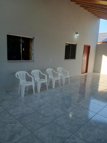 a group of white chairs sitting in a room at Casa Luna da Boa vista in Bonito