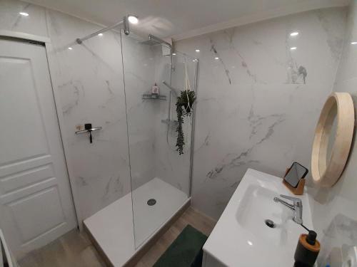une salle de bain blanche avec une douche et un lavabo dans l'établissement Sunshine, à La Ciotat