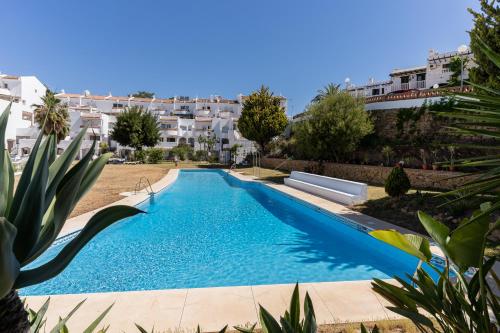 une piscine dans une cour avec des bâtiments en arrière-plan dans l'établissement MONKÓ VILLA CASABLANCA, à Benalmádena