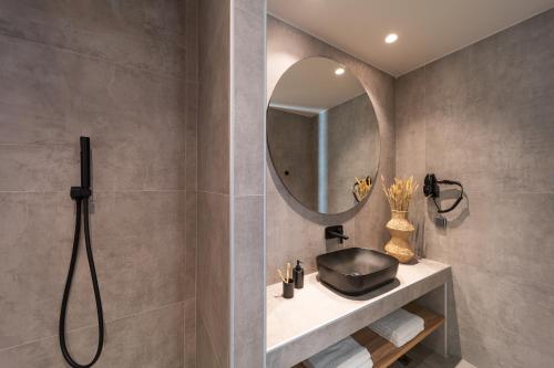 a bathroom with a sink and a mirror at Afesou Suites in Ialyssos