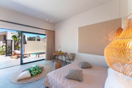 a bedroom with a bed and a view of a patio at Afesou Suites in Ialyssos