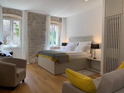 1 dormitorio con 1 cama, 1 sofá y 1 silla en Priuli Luxury Rooms, en Split