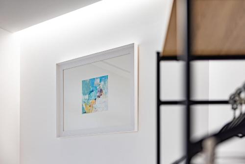 a picture on a white wall with a picture frame at Hostal Paris in Valladolid