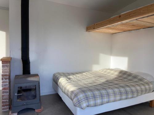 - une chambre avec un lit et un poêle à bois dans l'établissement The Cube, à Peille