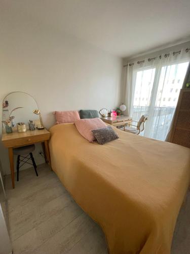 - une chambre avec un grand lit et une table avec un bureau dans l'établissement Joli Appartement, à Puteaux