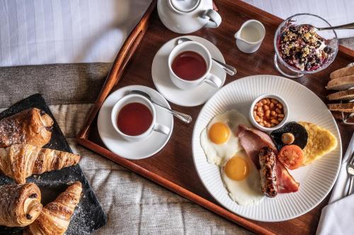 a tray with two plates of breakfast foods and cups of coffee at New Hall Hotel & Spa, Birmingham in Birmingham