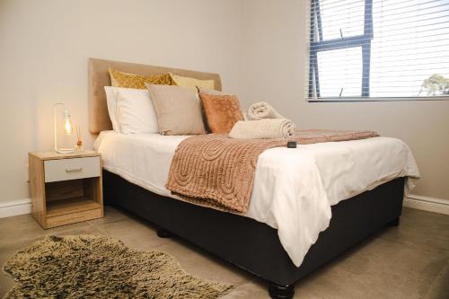 a bedroom with a large bed with a night stand at Luxury 2 Bed 2 Bath Apartment Incl Gym in Ballito