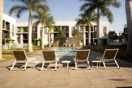 four chairs and a table in front of a building at Luxury 2 Bed 2 Bath Apartment Incl Gym in Ballito
