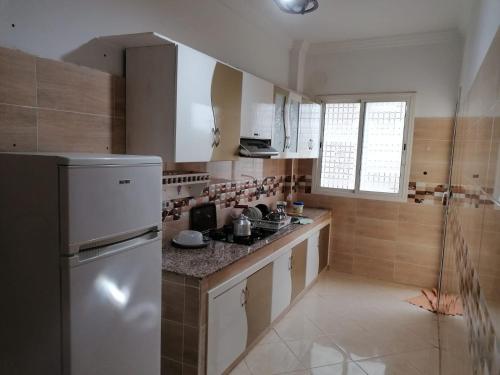 a kitchen with a refrigerator and a counter top at Jamila appart pr famille couples non in Meknès