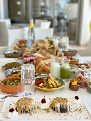 a table topped with plates of food on a table at Palm Djerba Suites in Mezraya