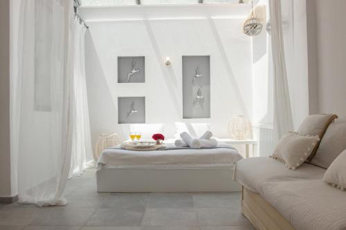 a white bedroom with a bed and a window at Serenity Villa in Sani in Sani Beach