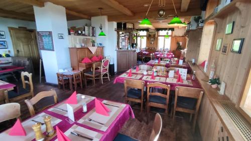 a restaurant with tables and chairs with pink napkins on them at Berggasthaus & Pension Schöne Aussicht in Klingenthal