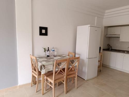 a kitchen with a table and chairs and a refrigerator at Apartamentos ORLANDO en Costa Adeje in Adeje