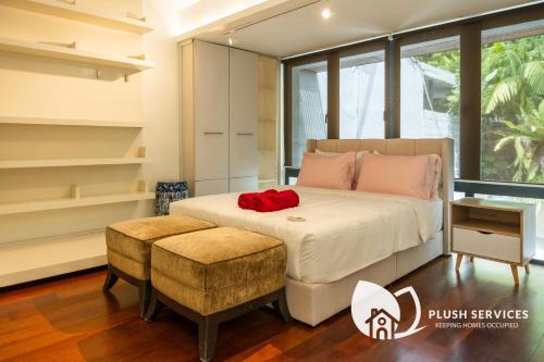 a bedroom with a bed and a stool in a room at Damansara Heights by Plush in Kuala Lumpur