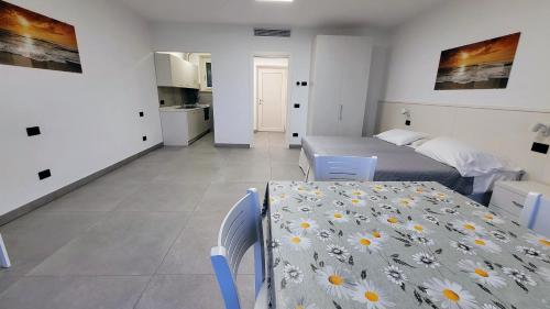 a bedroom with a bed and a table with flowers on it at Appartamenti Annachiara in Costermano sul Garda