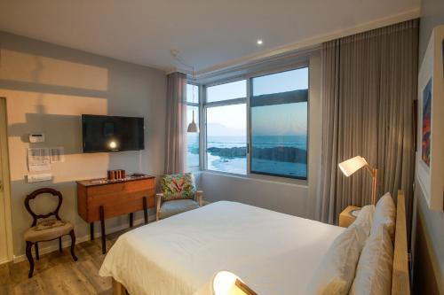 a hotel room with a large bed and a window at Bokkombaai in Bloubergstrand