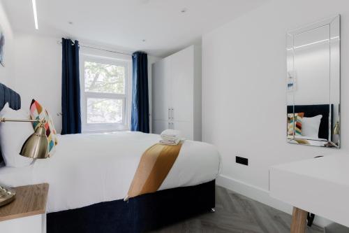 a bedroom with a large bed and a window at Comfortable Apartments near Harrods in London