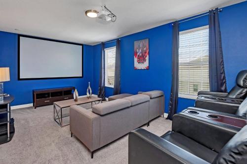 Sala de estar azul con sofá y pantalla en 8BR Luxury - Sleeps 22 - Near Disney with Pool & Hot Tub!, en Davenport