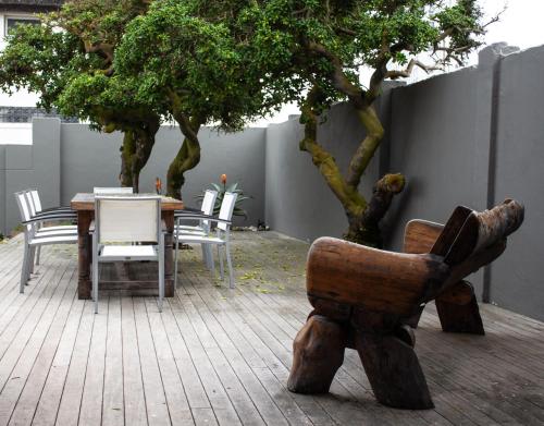 a chair and a table with chairs and trees at Bokkombaai in Bloubergstrand
