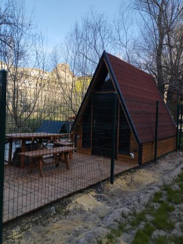 a large wooden building with a picnic table and benches at Fio's Garden camping otel in Aksaray