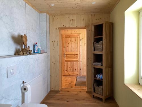 baño con puerta de madera en una habitación en Ferienwohnungen im Teichland Linum, en Linum