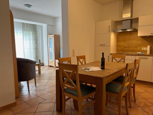 a kitchen and dining room with a wooden table and chairs at Gabi mit Pool und Sauna in Übersee