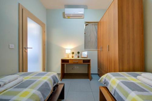 1 dormitorio con 2 camas y armario de madera en Sliema 2 Bedroom close to seafront en Sliema