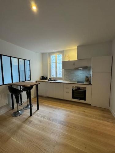 - une cuisine avec une table et un piano dans la chambre dans l'établissement Appartement Hyper centre, à La Rochelle