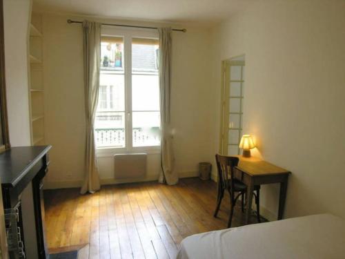 un salon avec une table et une fenêtre dans l'établissement 1 bedroom flat, Haut Marais, 3ème, à Paris