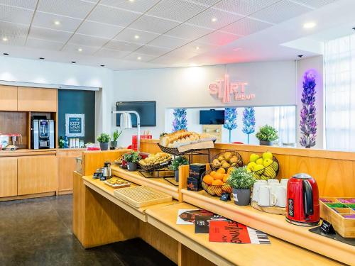 a cafeteria with a counter with fruits and vegetables at Hotel ibis Evora in Évora