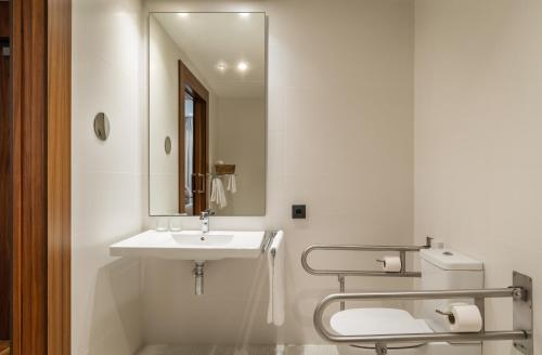 Baño blanco con lavabo y espejo en Hotel SB Glow Sup, en Barcelona