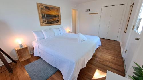 a bedroom with a white bed with two lights on it at Harbert's Gem in Harbert