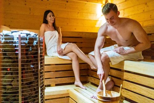 a man and a woman sitting in a sauna at BIO HOTEL & WELLNESS Zlatý Hýľ in Hýľov