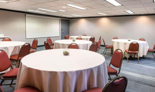 a conference room with tables and chairs and a whiteboard at Hyatt House Herndon/Reston in Herndon