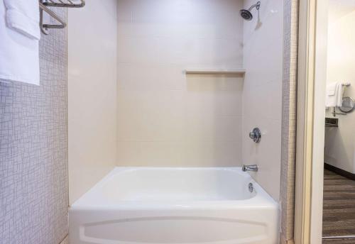 a bathroom with a white tub and a toilet at Hyatt House Herndon/Reston in Herndon