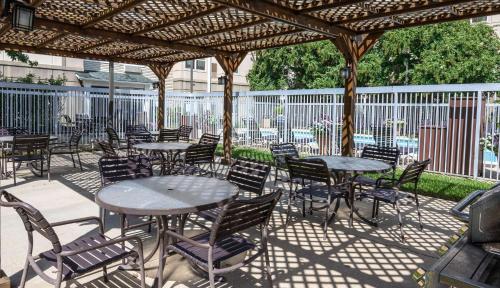a patio with tables and chairs under a pergola at Hyatt House Herndon/Reston in Herndon