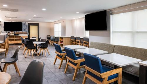 a dining room with tables and chairs and televisions at Hyatt House Herndon/Reston in Herndon