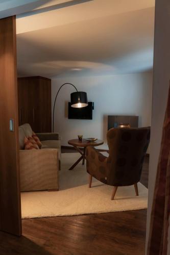 a living room with a chair and a table at Heimspitze - Alpenhotel & Wirtshaus in Gargellen