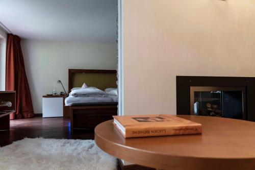 a room with a bed and a table with a book on it at Heimspitze - Alpenhotel & Wirtshaus in Gargellen