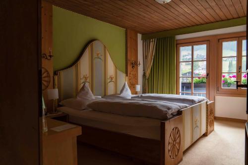 a bedroom with a large bed with a large mirror at Heimspitze - Alpenhotel & Wirtshaus in Gargellen