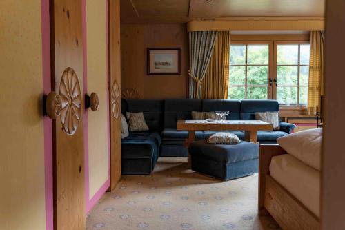 a living room with a blue couch and a table at Heimspitze - Alpenhotel & Wirtshaus in Gargellen