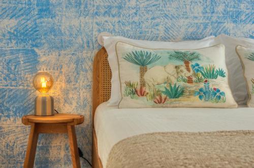 a bed with a pillow and a lamp on a table at Blue Bay, charming home in Póvoa de Varzim