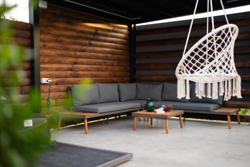 a patio with a couch and a hanging chair at Golden Pinpoint in Gornje Vratno