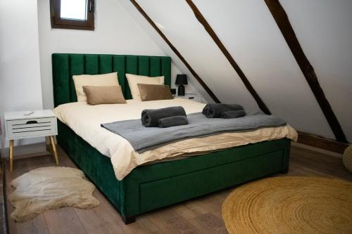 a bedroom with a bed with a green headboard at Golden Pinpoint in Gornje Vratno