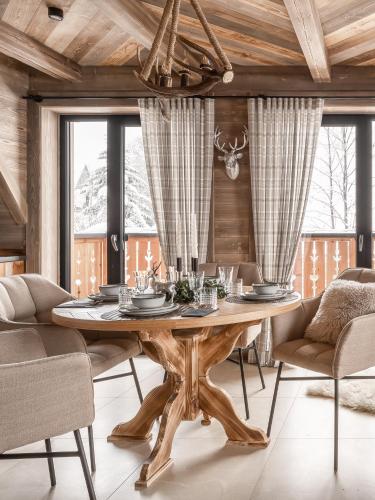 a dining room with a wooden table and chairs at Sichlańskie Spanie in Murzasichle
