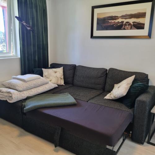 a couch with pillows on it in a living room at Apartment near center / free P in Ålesund